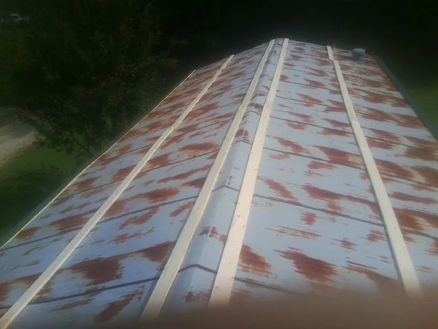 Rusted metal roof panels with new wood purlins before replacement — Storm Damage Roof Repair in Bay City by Roofing Brothers